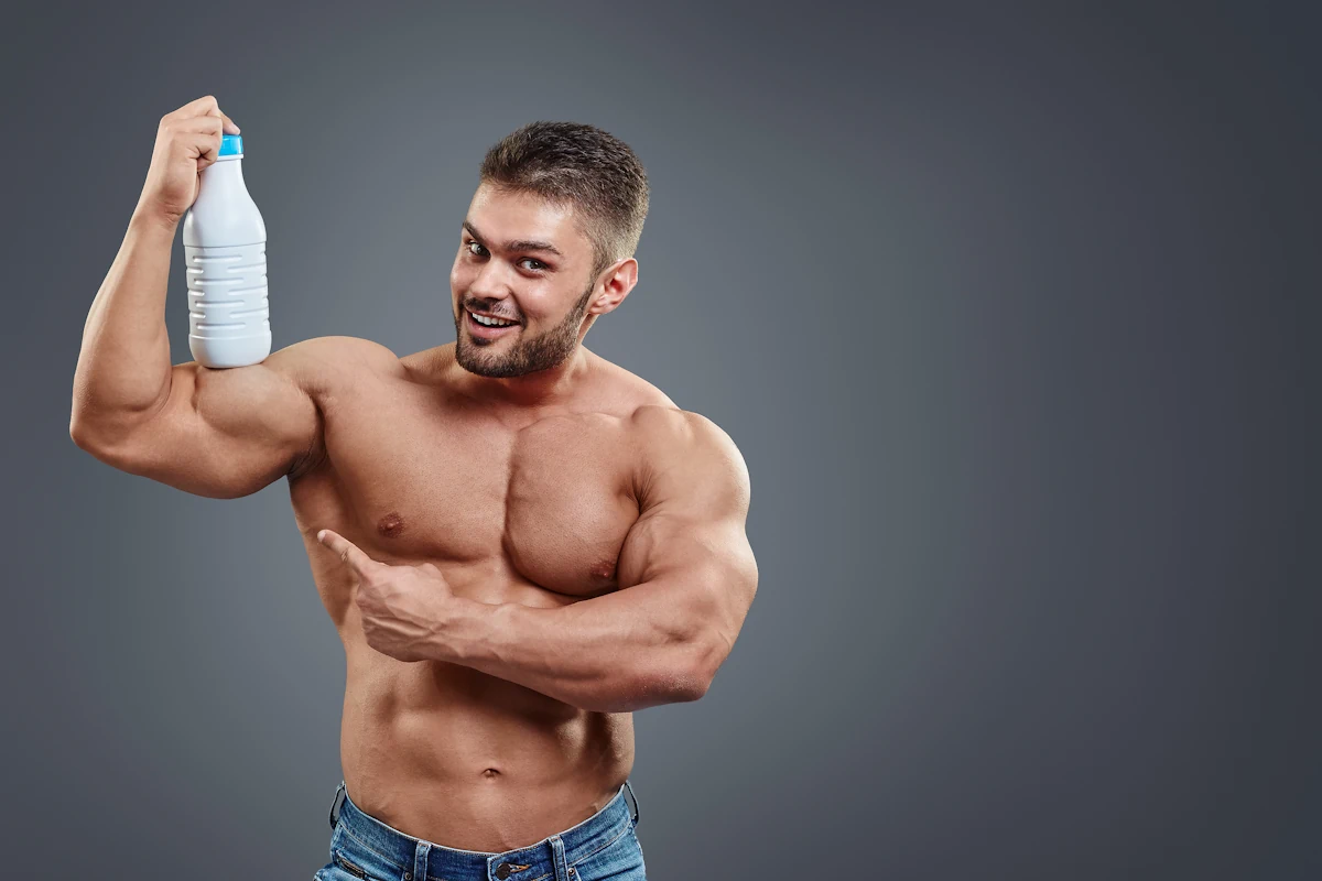 Un homme qui tient une bouteille de lait sur ses muscles