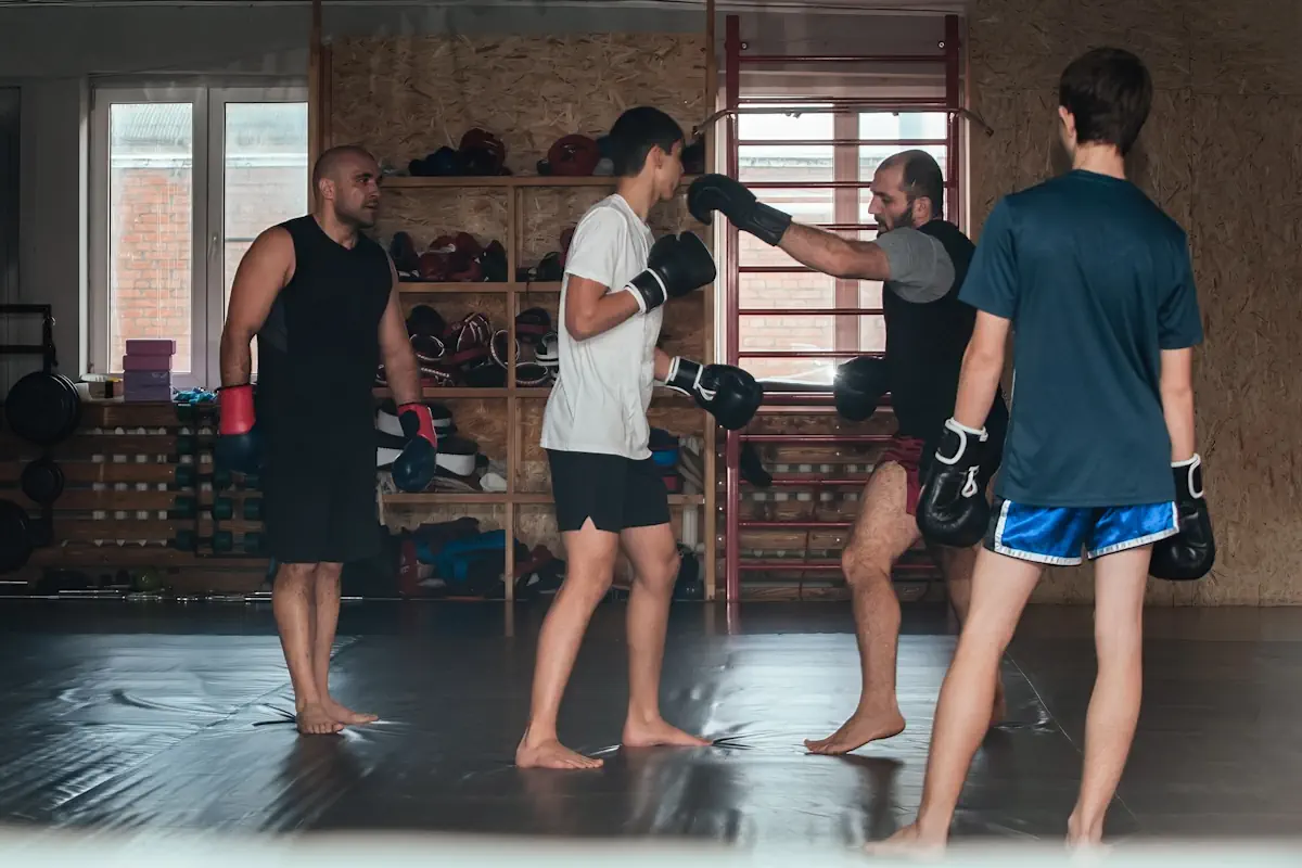 Quatre hommes s'entraînant au combat dans une salle