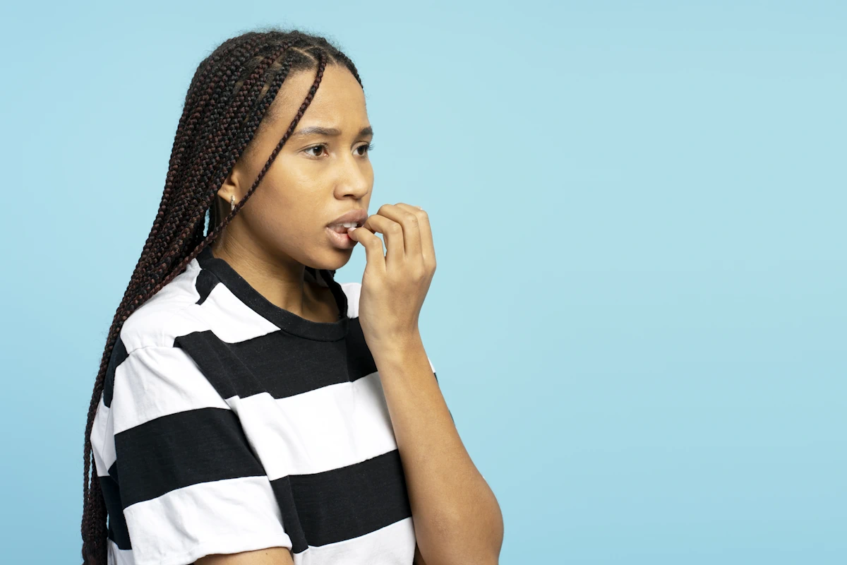 Une jeune femme se rongeant les ongles
