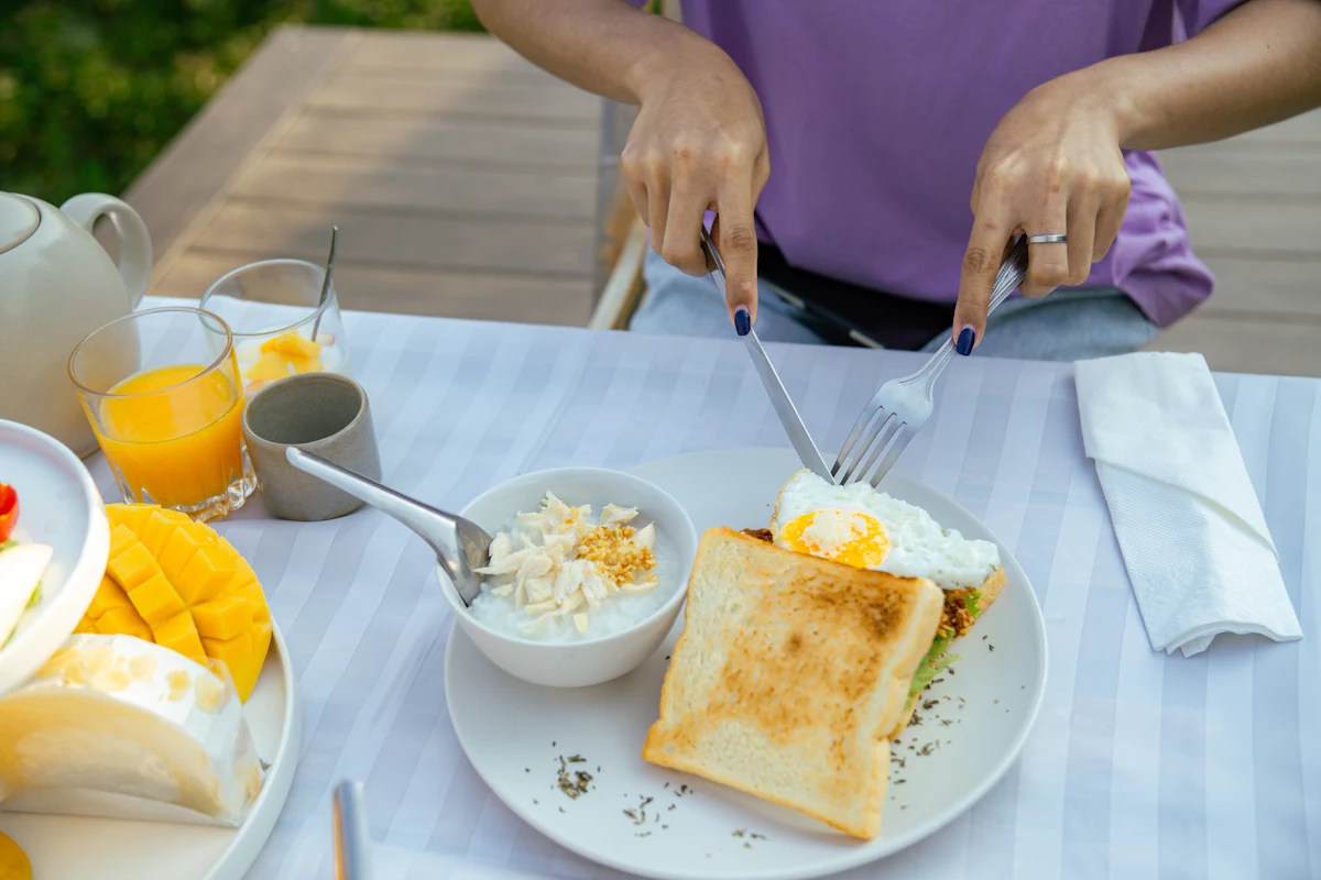Une personne qui mange des œufs aux petit-déjeuner