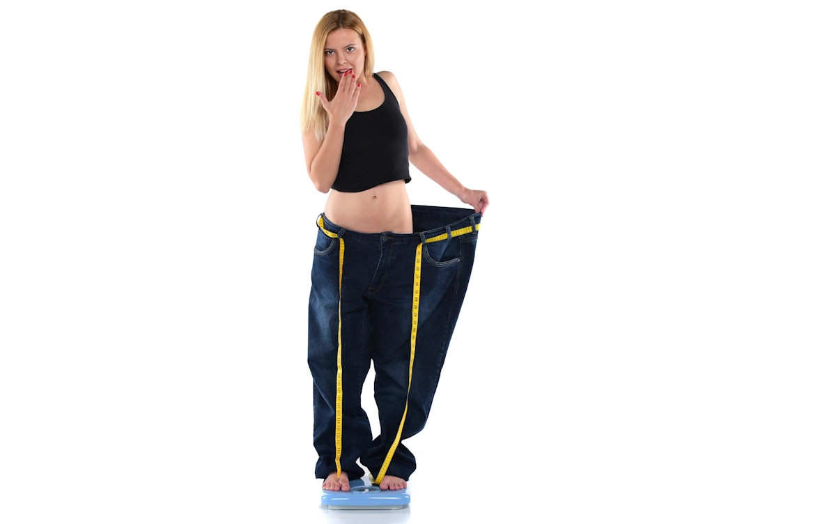 Une femme qui prouve sa perte de poids grâce au pilates